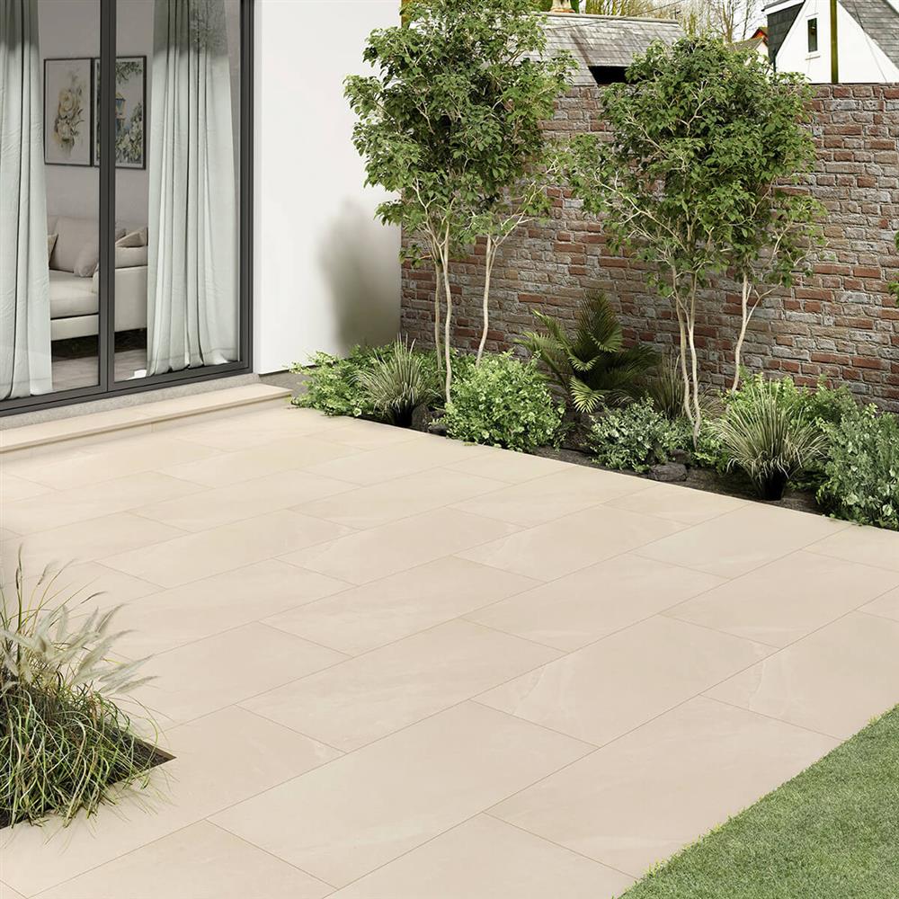 Low-maintenance porcelain patio in warm beige and border planting